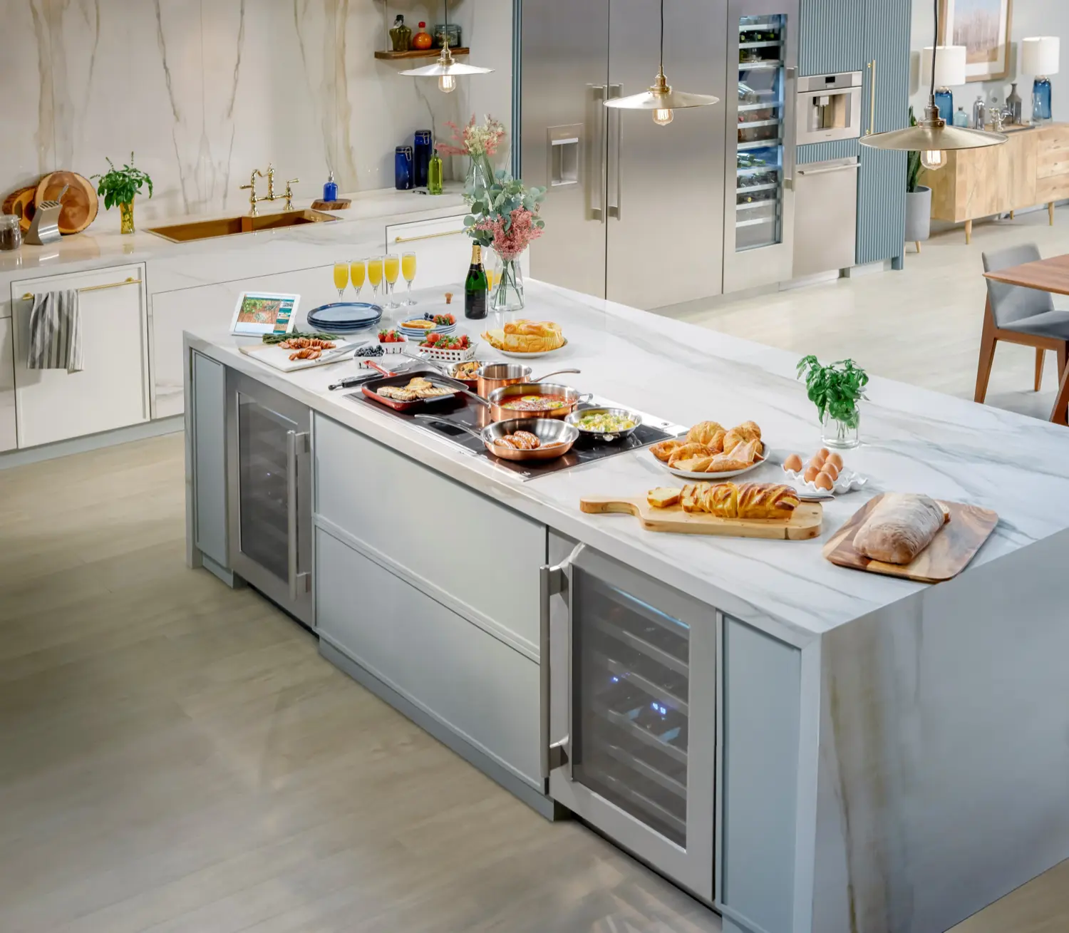 Modern Thermador kitchen featuring Liberty induction cooktop on marble island with integrated wine refrigerator and Freedom column refrigeration, showcasing complete appliance package eligible for free gifts promotion