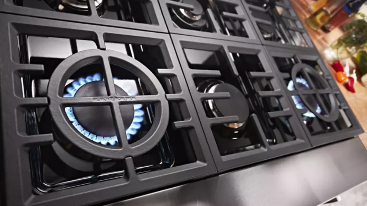 Top view of KitchenAid KFDC506JSS gas burners showing dual-flame 20,000 BTU configuration with blue flames
