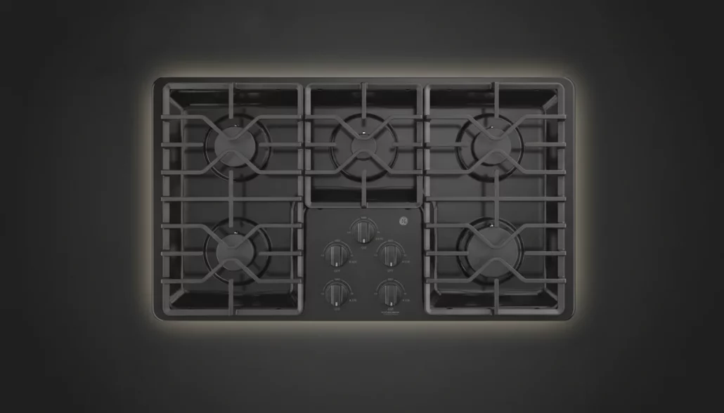 GE JGP3036DLBB 36-inch black gas cooktop showing complete 5-burner layout with cast iron grates and integrated control panel