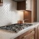 Gas cooktop in a quiet luxury kitchen with walnut cabinetry and marble countertops