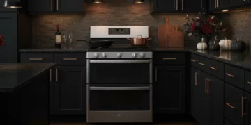 GE Profile double oven gas range installed in modern kitchen with dark cabinetry and brass accents